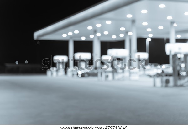 Blurred image of gas station at night. Defocused,
out of focus gas station and convenience store in evening twilight.
Abstract blur petrol station background with copy space. Vintage
filter look.