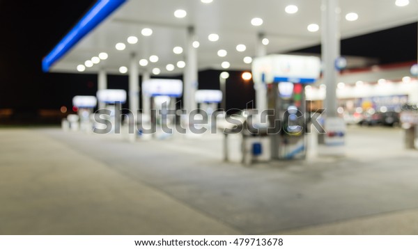 Blurred image of gas station at night. Defocused,\
out of focus gas station and convenience store in evening twilight.\
Abstract blur petrol station background with copy space. Panorama\
style.