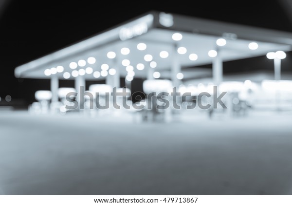 Blurred image of gas station at night. Defocused,\
out of focus gas station and convenience store in evening twilight.\
Abstract blur petrol station background with copy space. Vintage\
filter look.