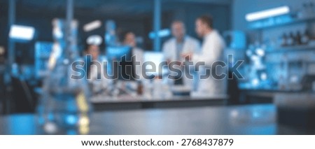 Blurred image of a group of scientists in lab coats collaborating and discussing research findings in a high-tech laboratory setting.