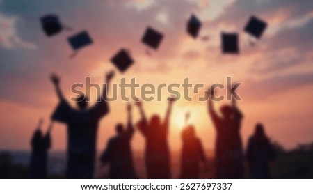 A blurred image of a group of students throwing graduation caps in the air during a sunset celebration outdoors