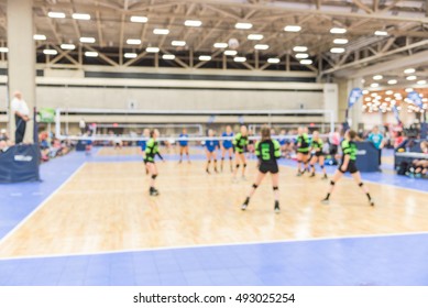 Blurred Image Group Of Teen Girls Playing Indoor Volleyball. Volleyball Competition Blur Background. High School Volleyball Tournament Concept.