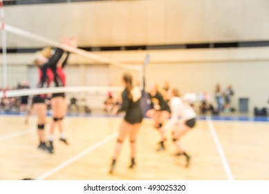 Blurred Image Group Of Teen Girls Playing Indoor Volleyball. Volleyball Competition Blur Background. High School Volleyball Tournament Concept.