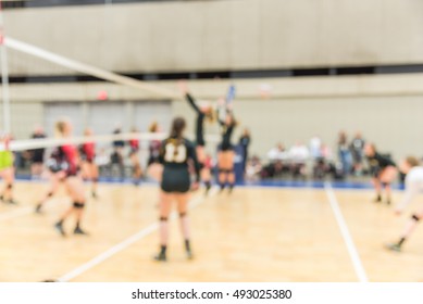 Blurred Image Group Of Teen Girls Playing Indoor Volleyball. Volleyball Competition Blur Background. High School Volleyball Tournament Concept.