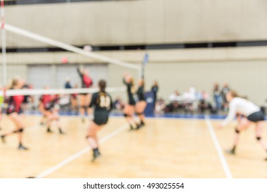 Blurred Image Group Of Teen Girls Playing Indoor Volleyball. Volleyball Competition Blur Background. High School Volleyball Tournament Concept.