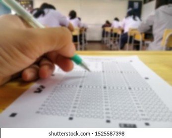 Blurred image of hand testing in exercise and taking fill in exam  paper computer sheet with pen at school test room, Academic Competition Exam, education concept.