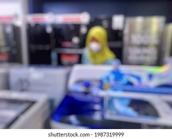 Blurred Image Of Hijab Girl Wear Mask Looking At Items In Electronics Store While Pandemic Covid 19
