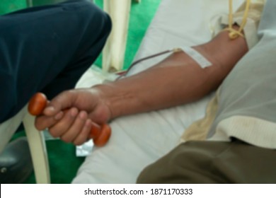 Blurred Image Of Indian Male Volunteer Holding Dumbbell And Donating Blood At Blood Donation Camp. Kolkata, West Bengal, India.