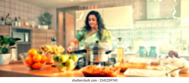Blurred Image, Indian Women Chef Cooking Food In Kitchen For Dinner ,bokeh Lights .high Quality Image. Chef Cooking In Restaurant Kitchen  Blurred Defocused Background