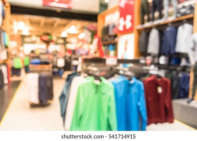 Blurred Image Interior Of Sports And Fitness Clothing Store In America. Sport Shop With Famous Sports Fashion Brand Worldwide Of Athletic Shoes, Gear And Apparel. Healthy Lifestyle Concept Background.