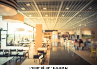 Blurred Image Large Cafeteria, Canteen, Food Court At Shopping Mall Or Corporate In Texas, USA. Defocused Modern Public Dining Area Natural Lights From Windows For Background Use, Customer Eating