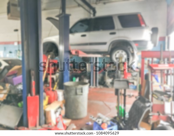 Blurred image of lifted car at auto repair shop\
in America