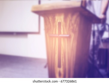 Blurred image of a man  making speech from behind the pulpit with Jesus cross in church service, can  be used for christian background - Shutterstock ID 677326861