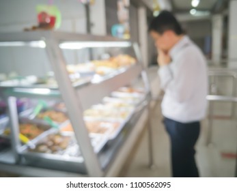 Blurred Image Of Man Wearing Business Suit In Canteen Or Office Cafeteria At Food Display Cabinet And Selecting Various Food