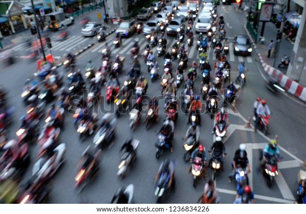 Blurred image of motorcycle taxis and\
\
motorcyclist  weave through Bangkok\'s during intense rush-hour\
traffic.They keep things moving. When the light changed to\
green,\
they were the first people\
away.