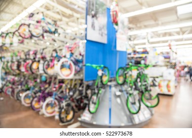 Blurred Image Multiple Rows Of Kid Bikes Hanging On Rack At Department Store In Humble, Texas, US. Various Bright Color Bicycles For Active Kids In Bike Shop. Healthy Lifestyle Concept Background.