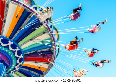 Blurred Image Of People Enjoying A Carnival Ride At An Amusement Part