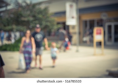 Blurred image of people out shopping at pedestrian outdoor courtyards and covered walkways in outlet mall in Houston, Texas, US. Wide range of retailers of designer apparel and jewelry. Vintage filter