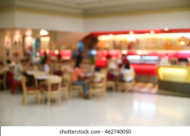 Blurred image people sit and eat ice cream on the table, ice cream shop in the mall.