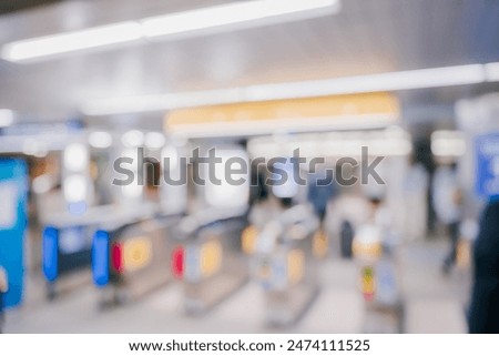 Blurred image of people using ticket gates at a train station