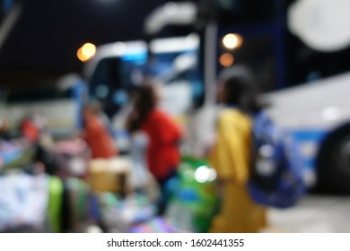 Blurred Image Of People Wait For Bus Inside Bus Terminal For Long Holiday, New Year Festival In Night Time For Come Back To See Their Family. They Carry Passenger's Goods And Luggage.