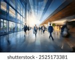 A blurred image of people walking in a modern office building with large glass windows.