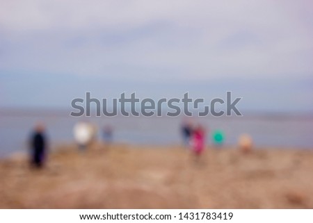 zwei erwachsene und ein kind in badebekleidung auf einem roller am meer. verschwommen