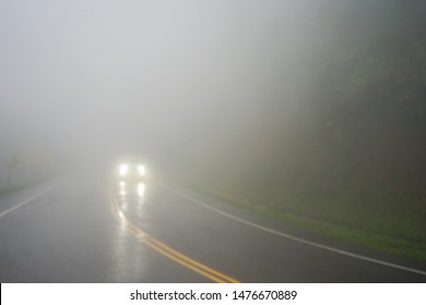 Blurred image, Poor or low visibility in foggy road. Car turn on the light and slowly driving in dangerous weather. Unexpected and obstacle in business, Safety driving on the road traffic concept - Powered by Shutterstock