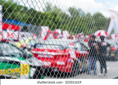 Blurred Image Of Racing Car On Track View From Behind Fence 