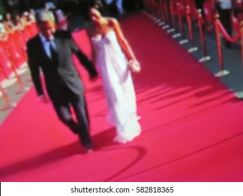 Blurred image. Red carpet entrance with golden stanchions and ropes. Celebrity nominees go to the premiere. Stars on the festive awarding of prizes awards
