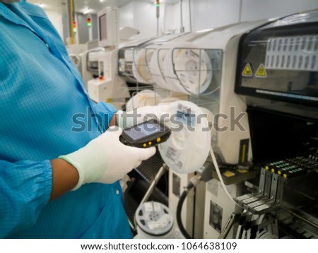 Blurred image of reel,  Hands of worker using PDA scan label barcode on reels component at Surface mount technology (SMT) for manufacturing of electronic equipment,Surface process and devices