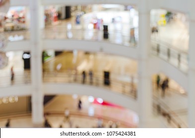 Blurred image, shallow depth of focus - interior of large multi-storey shopping center. Abstract background with empty copy space for text.