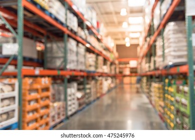 Blurred Image Of Shelves In Modern Distribution Warehouse Or Storehouse. Defocused Background Of Industrial Warehouse Interior Aisle. Inventory, Hypermarket, Wholesale, Logistic And Export Concept.