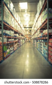 Blurred image of shelves in modern distribution warehouse or storehouse. Defocused background of industrial warehouse interior aisle. inventory, wholesale, logistic and export concept. Vintage filter.