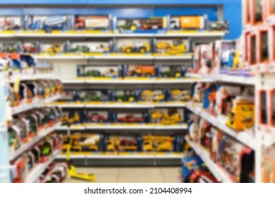 Blurred Image Of Shelves With Toy Cars In A Toy Shop. 