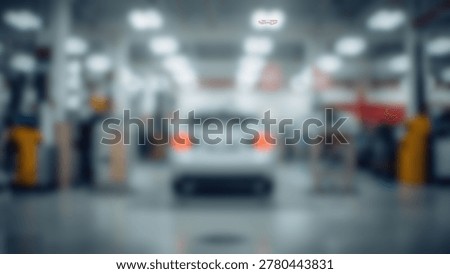 A blurred image showcasing a car inside a modern automotive repair shop, with various tools and equipment visible in the background. The focus is on the vehicle and the professional setting.