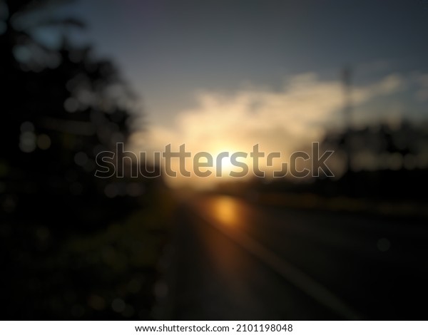 Blurred image\
of sunset on the road for\
background