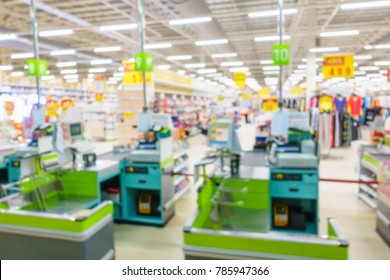 Blurred image of supermarket / hypermarket checkout counter or point of sale (POS) or point of purchase (POP) with cash register. Customers can make a payment in exchange for goods or service here.