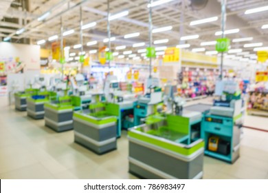 Blurred image of supermarket / hypermarket checkout counter or point of sale (POS) or point of purchase (POP) with cash registers. Customers can make a payment in exchange for goods or service here.