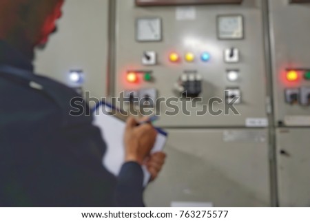 blurred image - technicians perform routine inspection work on main switchboard