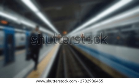 A blurred image of a train station platform, with a person waiting for the train. The image captures the essence of travel and transportation.