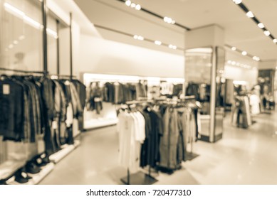 Blurred Image Of Wardrobe Inside A Men Fashion Store With Fall Collection. Abstract Blurred Of Shopping Mall Boutique Interior, Men Clothes Shop With Bokeh Light Background. Vintage Tone