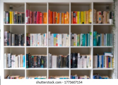 Blurred image of white wooden bookcase filled with books in a UK home setting
