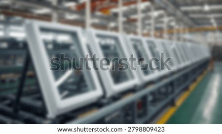 A blurred image of window frames moving along an assembly line, showcasing modern manufacturing processes in a factory setting.