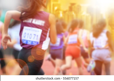 Blurred image of women marathon racing in the city with lans flare.