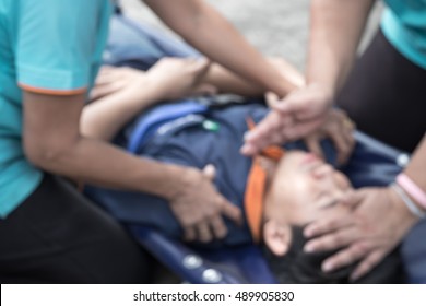 Blurred image of women trying to save a unconscious man, while waiting for 911 assistance - Shutterstock ID 489905830