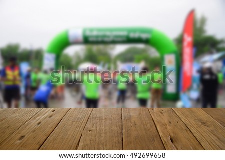 blurred image wood table and people riding bicycles bacground
