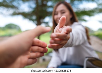 Blurred Image Of A Young Couple Reaching And Holding Hands 