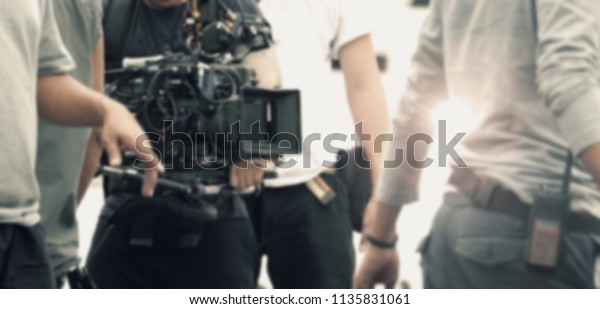 Blurred images of video camera and lens on steady\
equipment support such as gimbal steady or stabilized shoulder rig\
and pan tilt shift head tripod for handheld filming a fast moving\
object in tvc