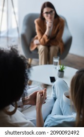 Blurred Interracial Same Sex Couple Holding Hands During Psychological Consultation